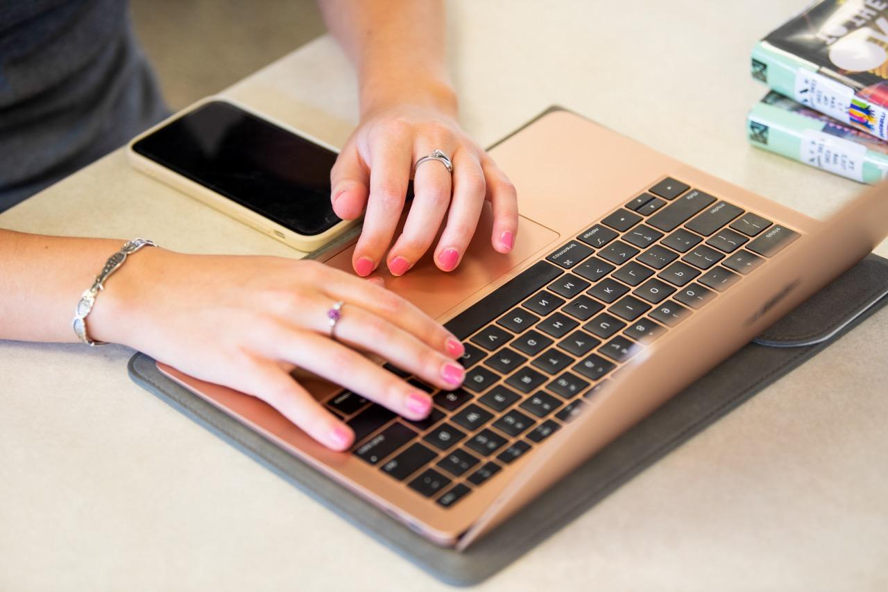 一个女人的手在笔记本电脑上打字